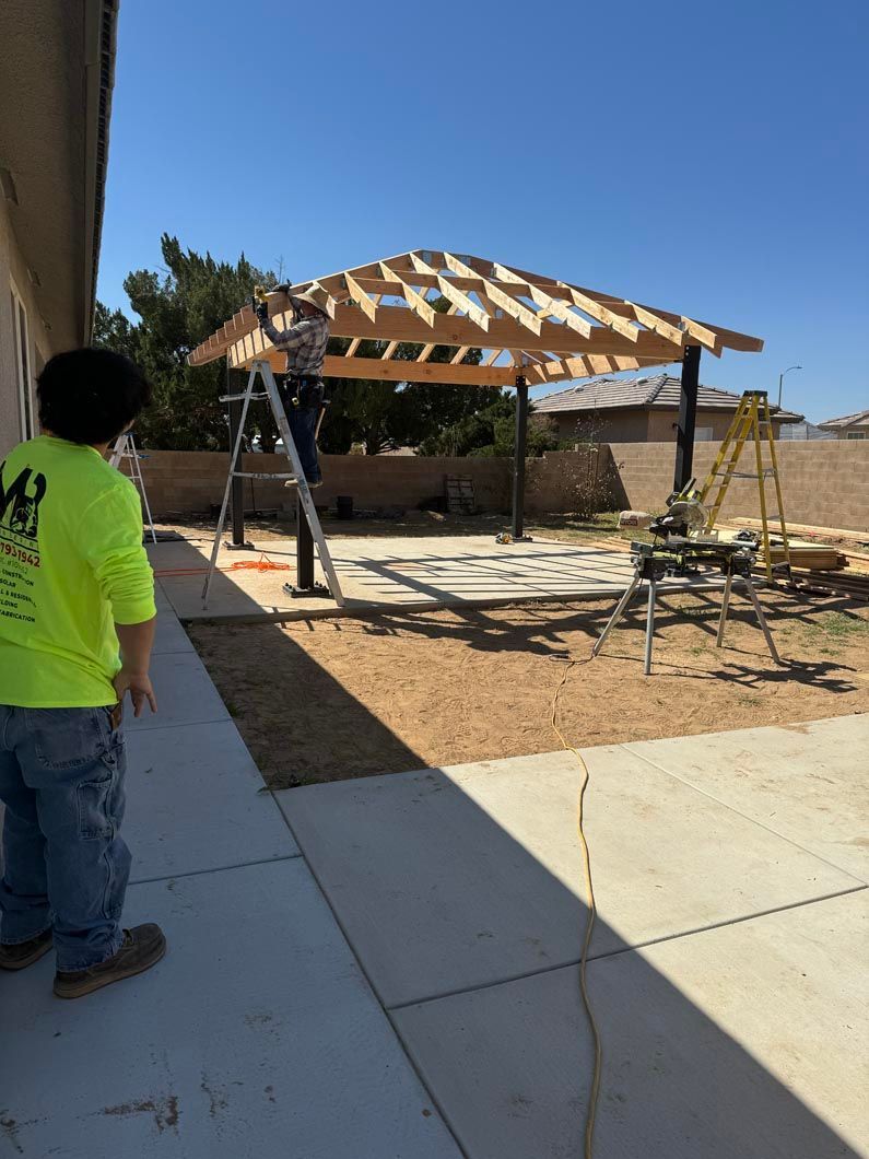 A man in a neon yellow shirt is standing in front of a building under construction.