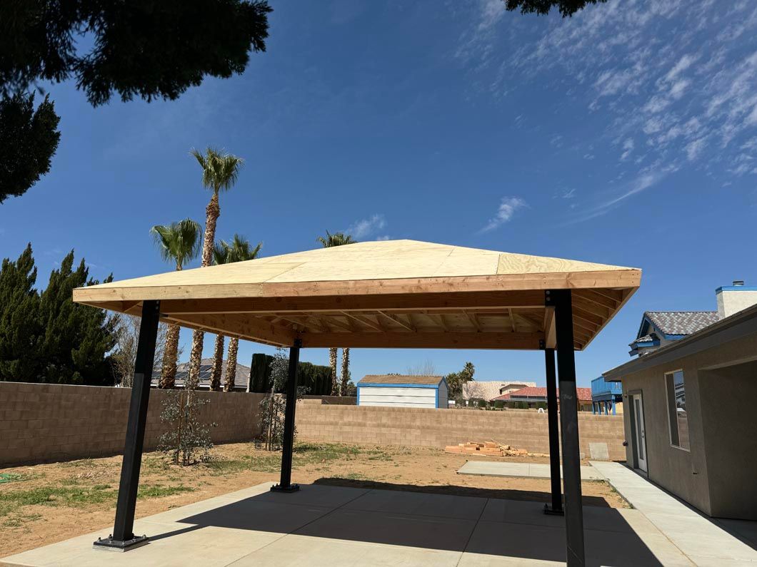 A gazebo is being built in the backyard of a house.