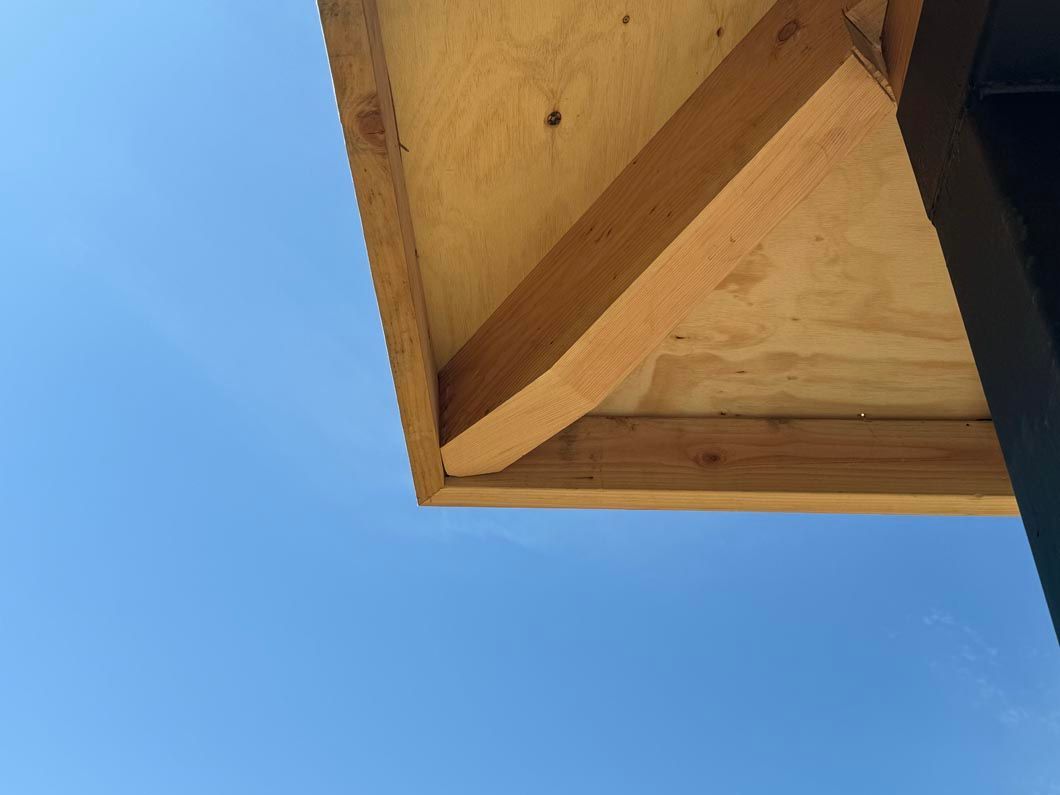 Looking up at a wooden structure with a blue sky in the background.