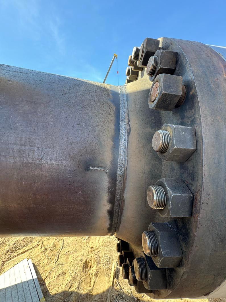 A close up of a metal pipe with nuts and bolts on it.