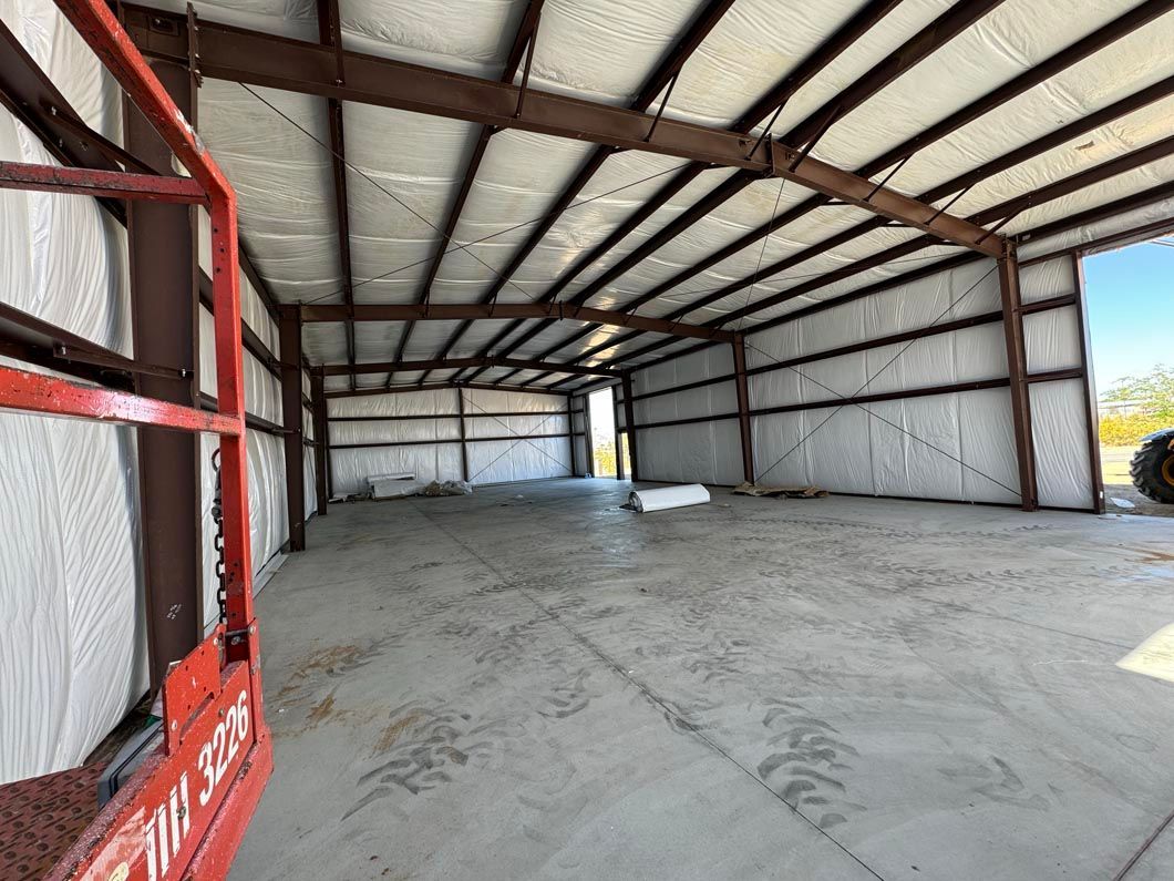 A large metal building with a tractor parked in front of it.