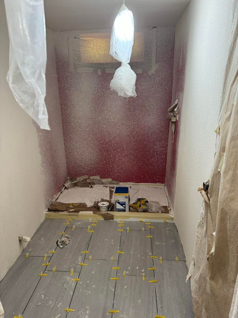 A small room with a red wall and a light hanging from the ceiling.