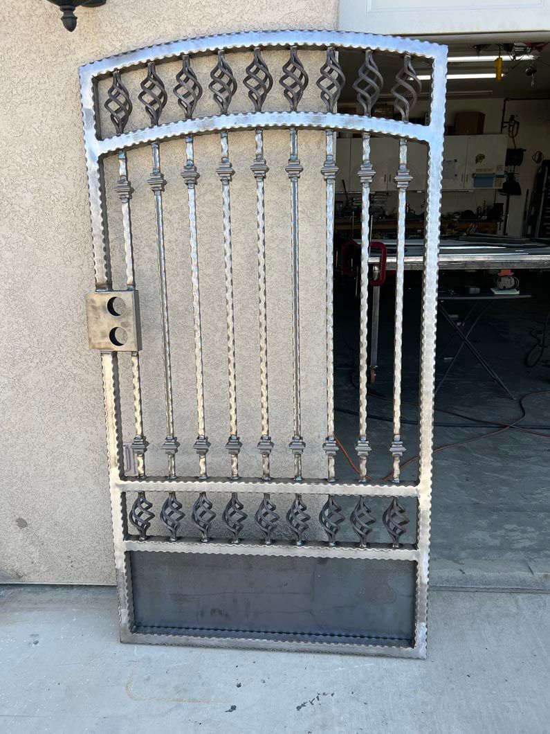 A wrought iron gate is sitting in front of a garage door