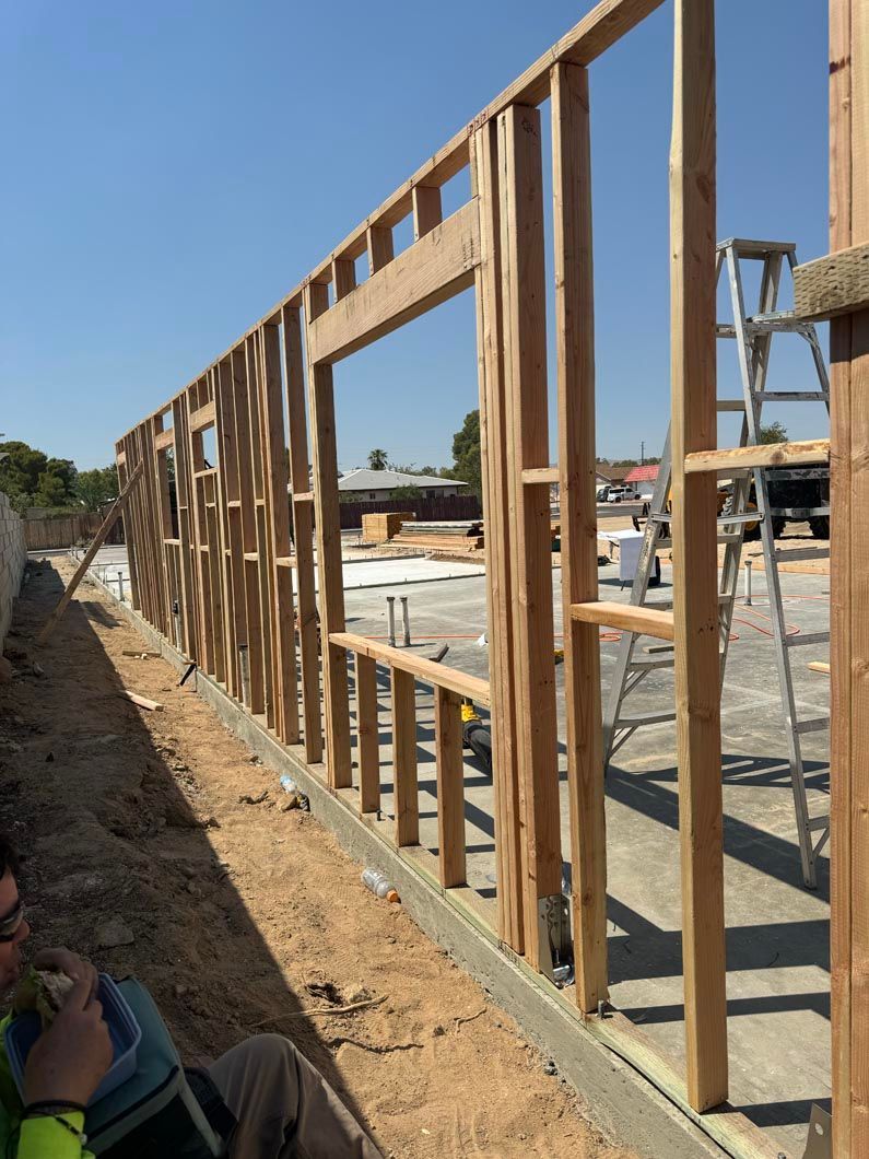 A man is sitting in front of a wall that is being built.