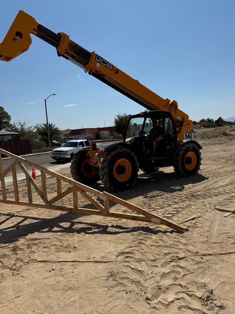 A yellow forklift is lifting a wooden structure in the dirt.