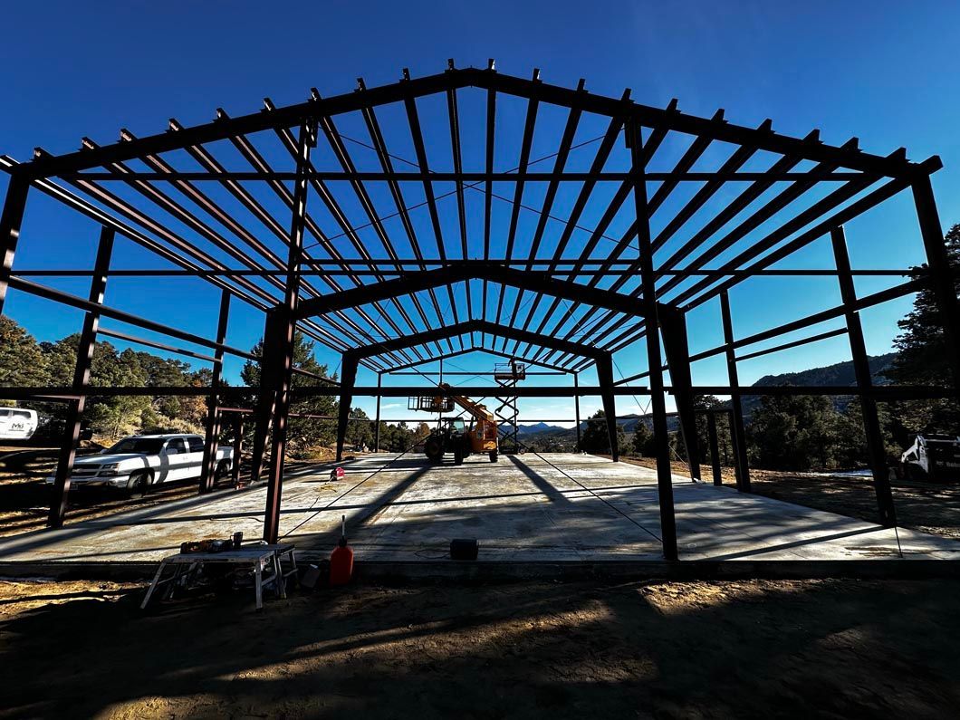A large metal structure is being built in the middle of a field.