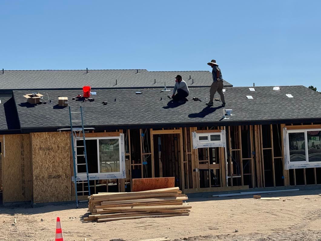 Two men are working on the roof of a house under construction.
