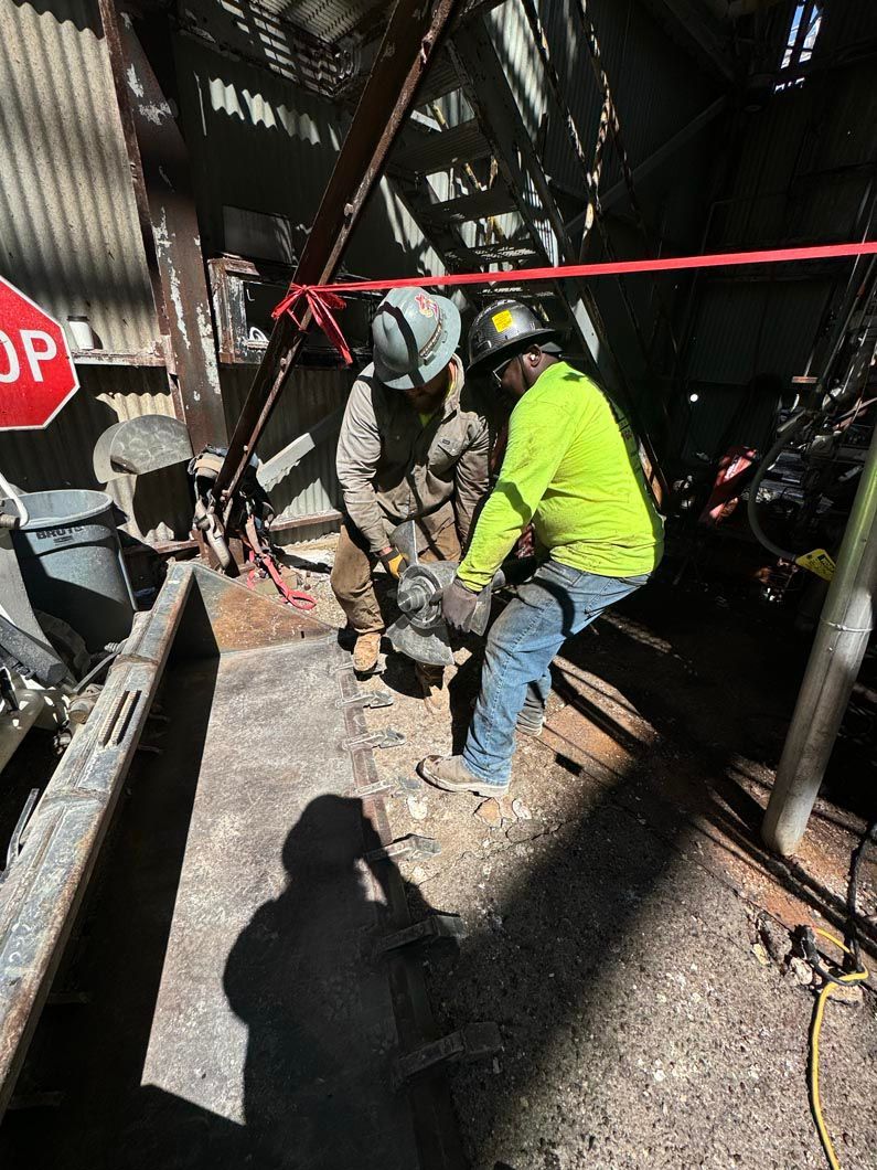 A group of construction workers are working on a construction site in front of a stop sign.