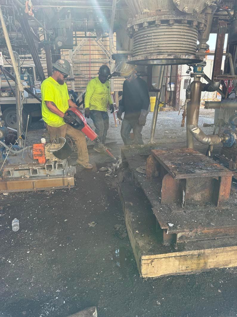 A group of construction workers are working on a large piece of metal.