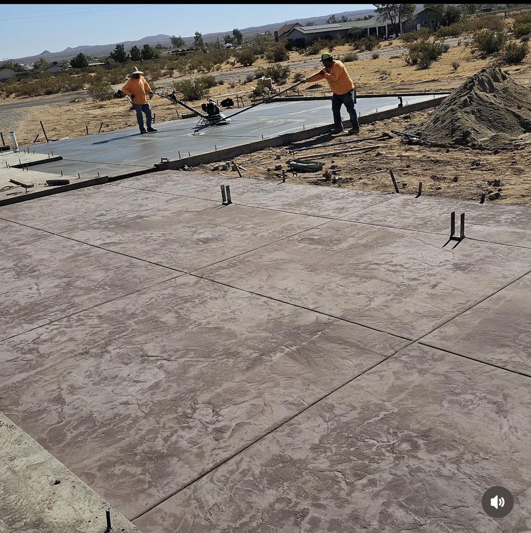A group of construction workers are working on a concrete floor.