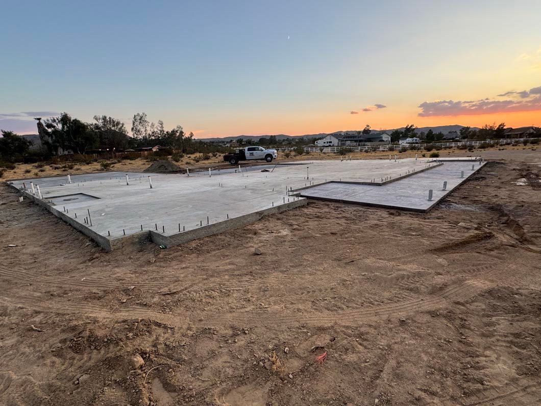 A large concrete slab is sitting in the middle of a dirt field.