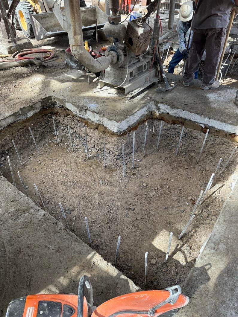A machine is sitting in the middle of a hole in the ground.