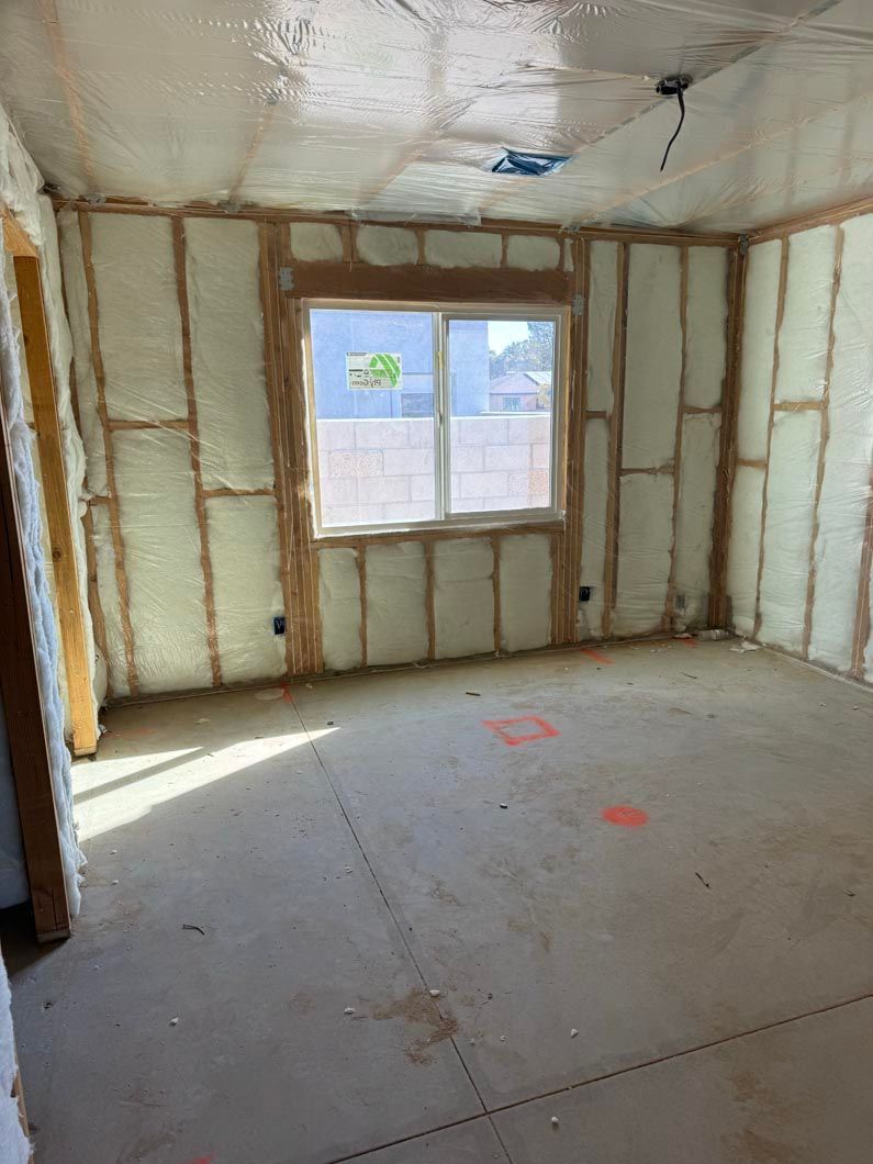 An empty room with foam insulation and a window.