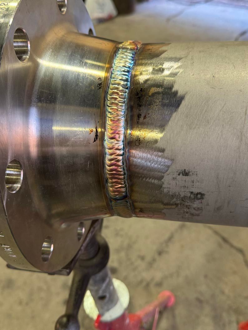 A close up of a metal pipe with a flange on it.