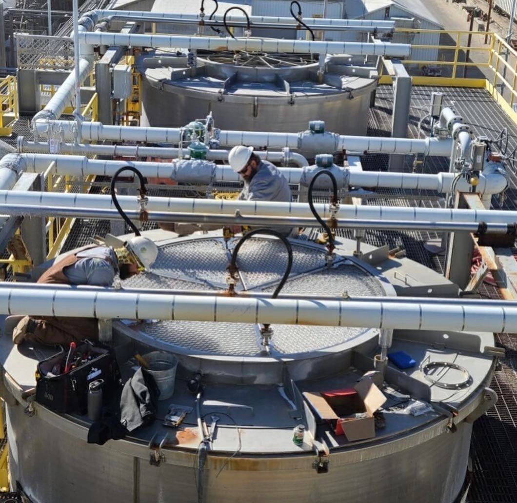 A man in a hard hat is working on a large metal object
