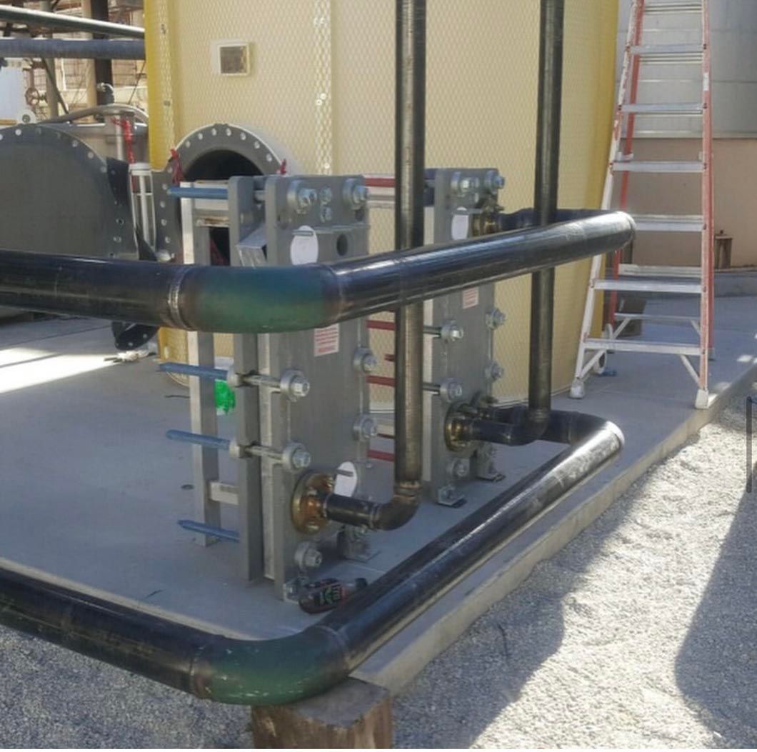 A ladder is sitting next to a row of pipes