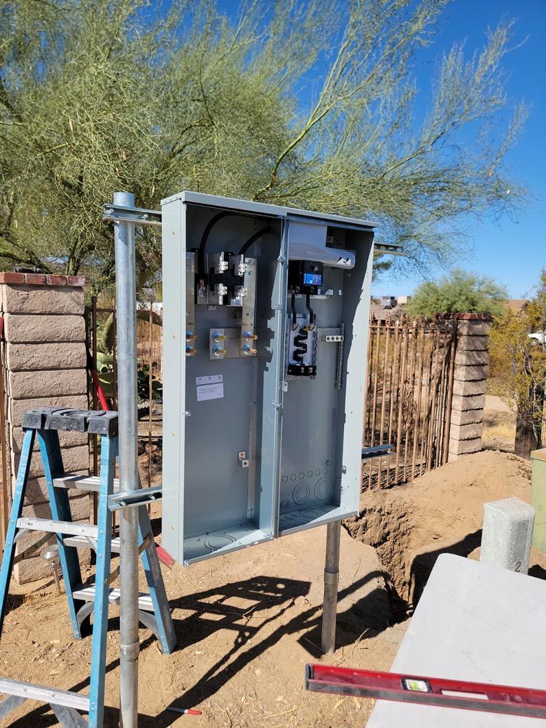 A ladder is sitting next to a box on a pole.