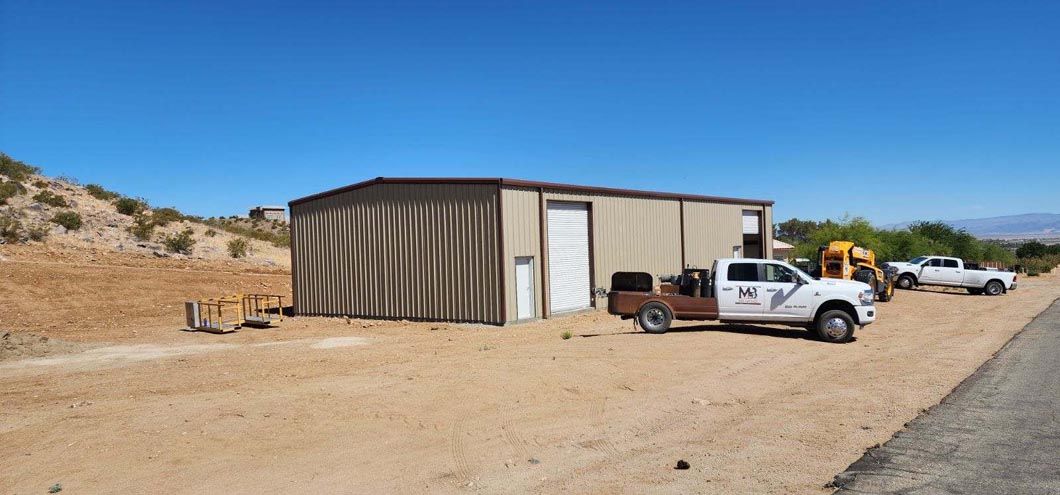 A truck is parked in front of a building in the desert.