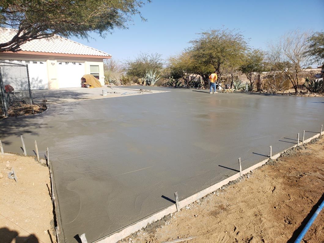 A concrete driveway is being poured in front of a house.
