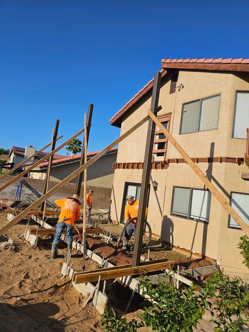 A group of construction workers are working on a house.
