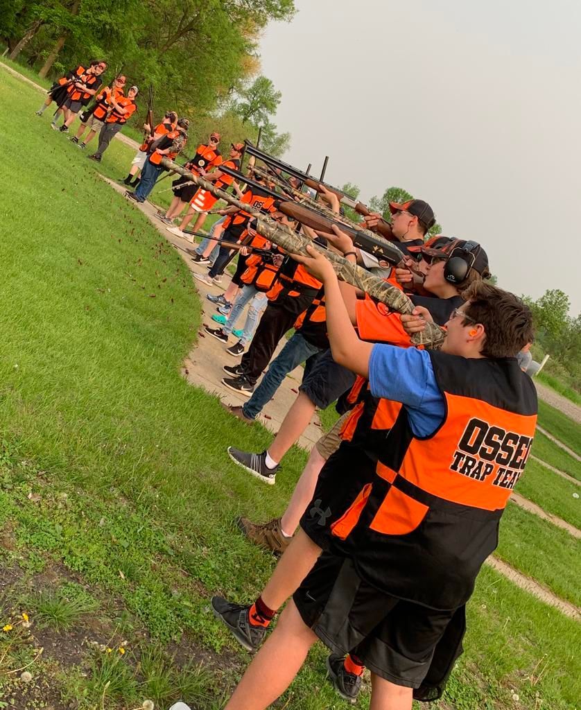 a group of young men are standing in a line shooting clay pigeons with rifles at fulton county gun club