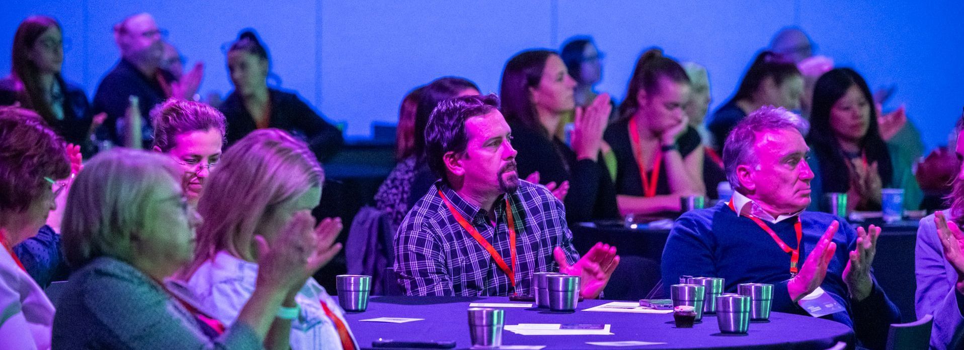 Conference attendees applauding.