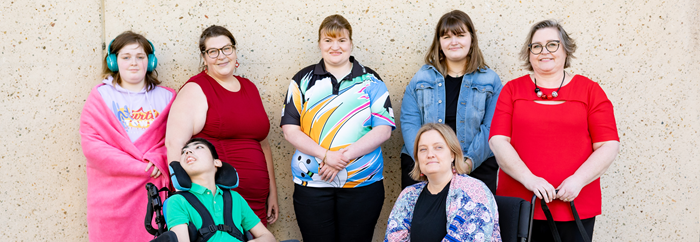 6 disabled women and 1 boy. 2 people are in wheelchairs and 1 has a support dog. 