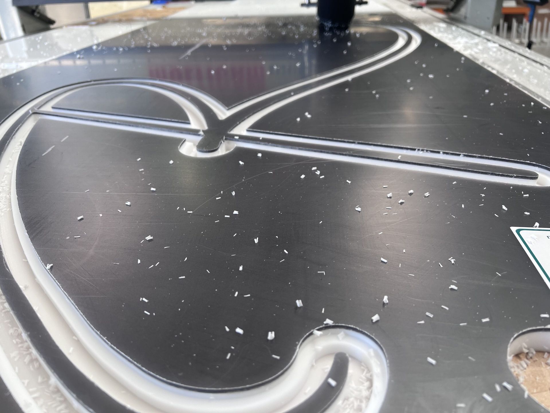 A Metal Surface With A White Design On It — Metric CNC In Morisset, NSW