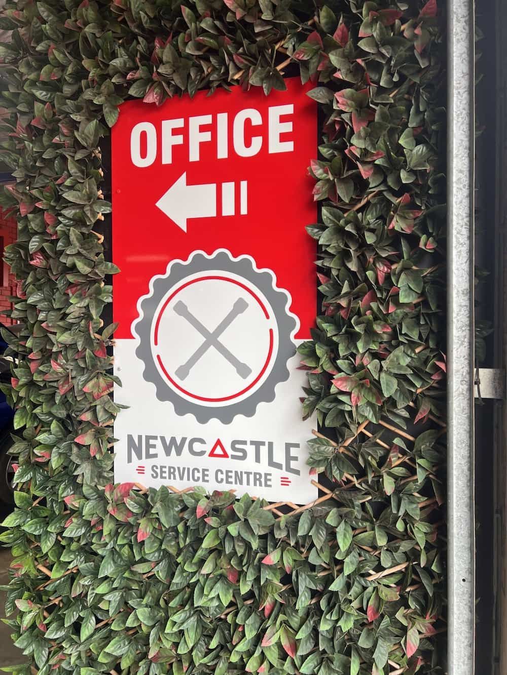 A Red and White Sign for the Newcastle Service Centre — Metric CNC In Morisset, NSW