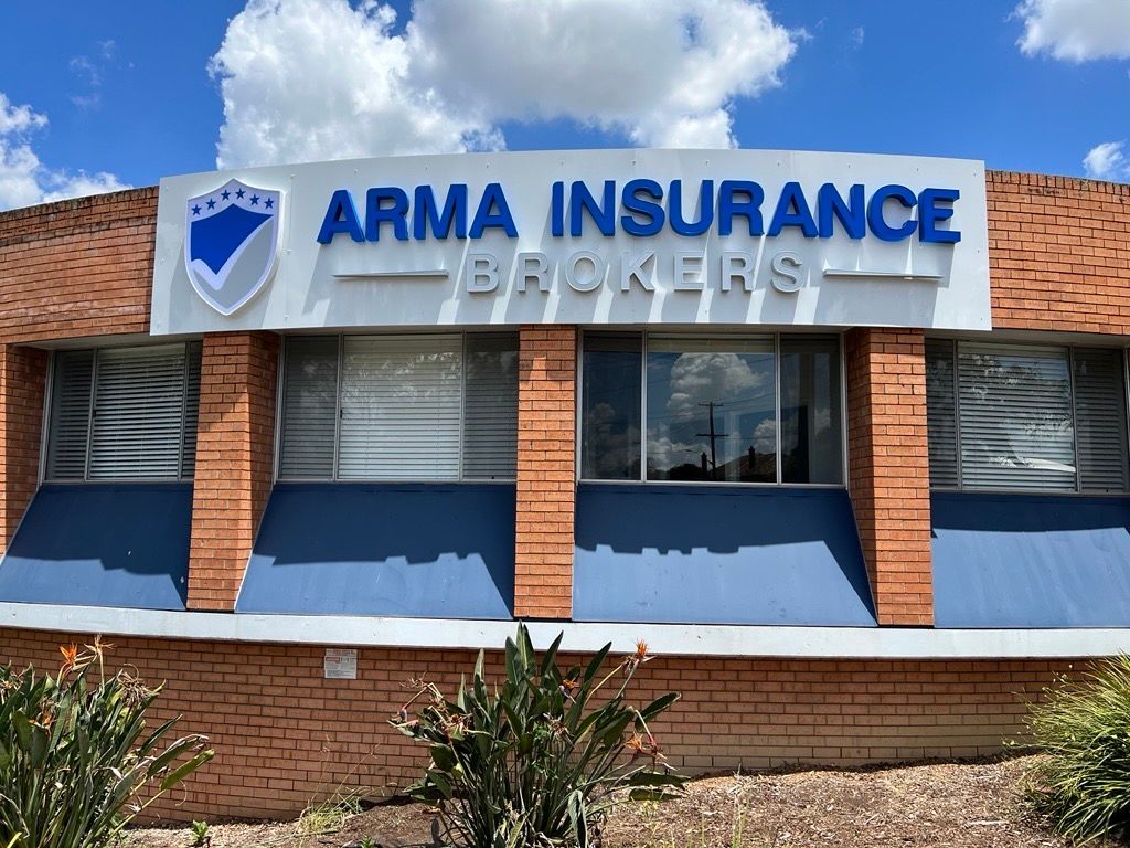 A Brick Building with a Sign that Says Arma Insurance Brokers — Metric CNC In Morisset, NSW