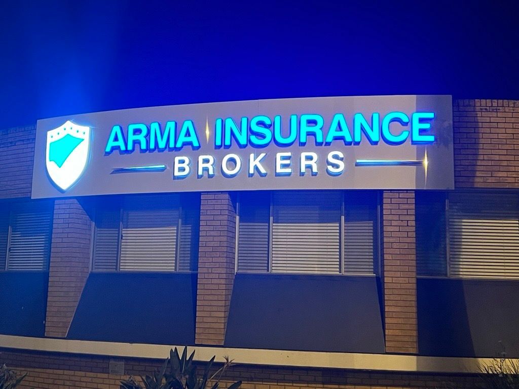 A Sign for Arma Insurance Brokers is Lit Up at Night — Metric CNC In Morisset, NSW