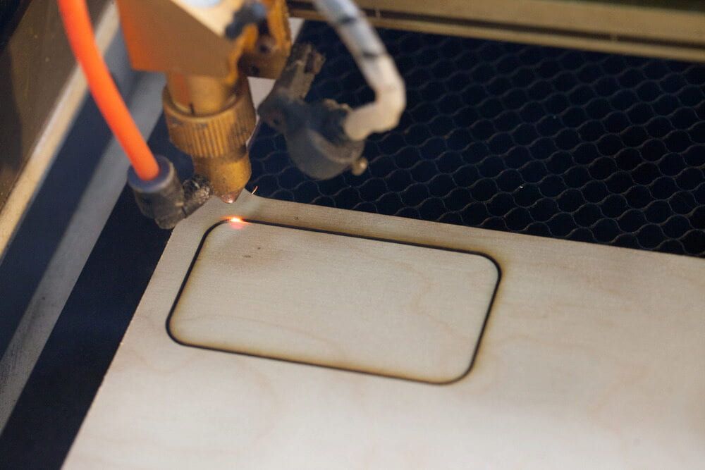 A Machine Is Cutting A Piece Of Wood With A Laser — Metric CNC In Central Coast, NSW