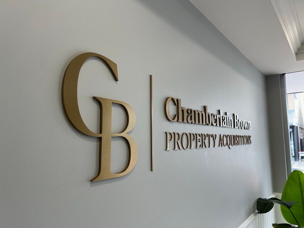 A Sign on a Wall that says Chamberlain's Property Acquisitions — Metric CNC In Morisset, NSW