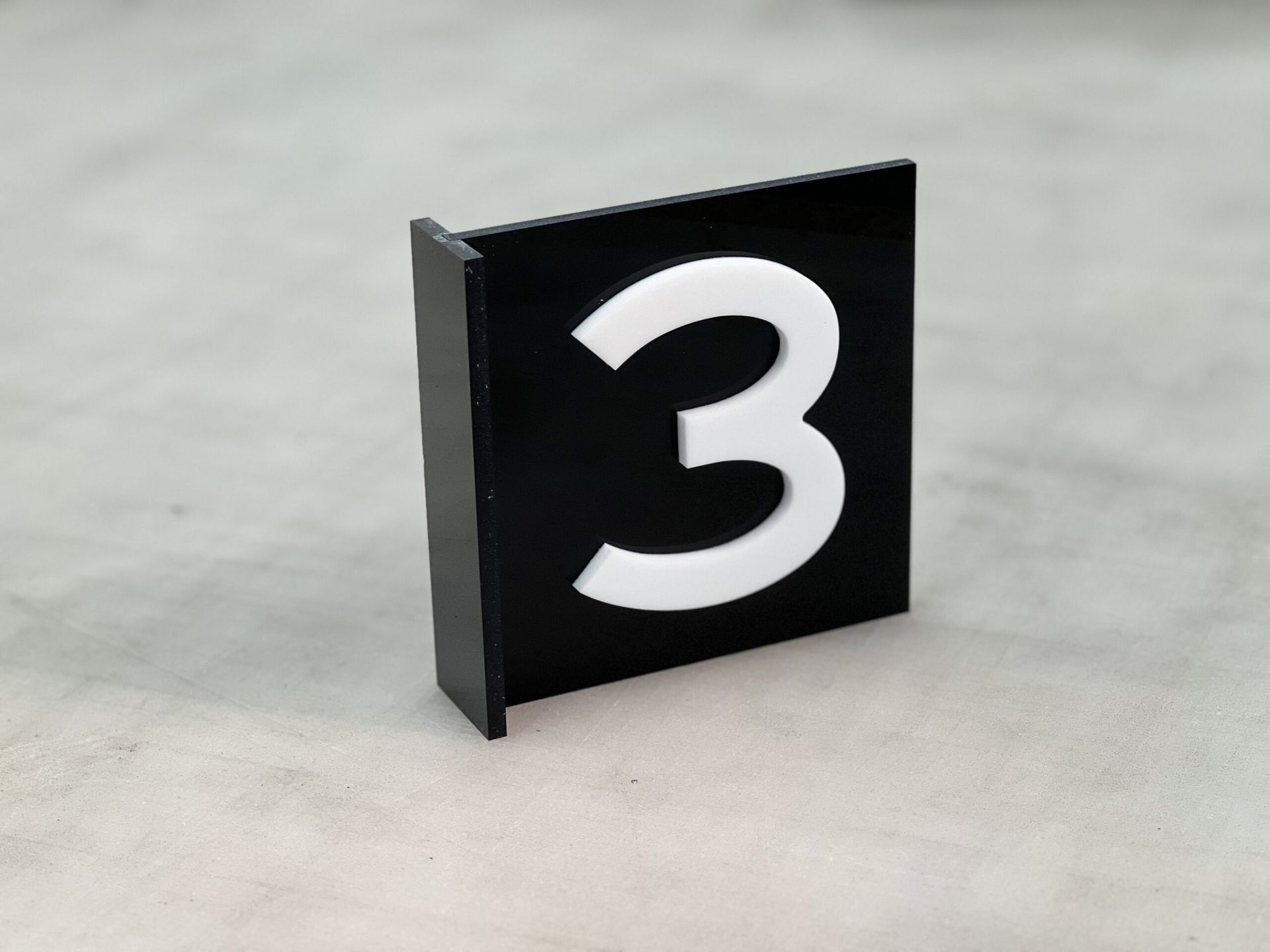 A Black And White Sign With The Number Three On It — Metric CNC In Morisset, NSW