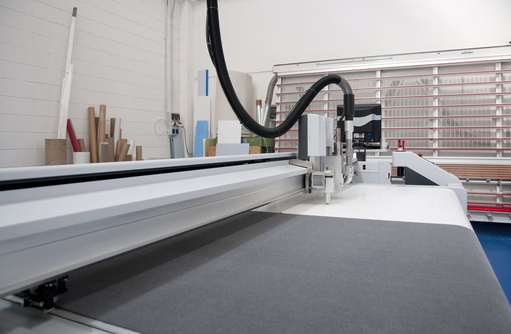A Machine Is Cutting A Piece Of Fabric In A Room — Metric CNC In Morisset, NSW