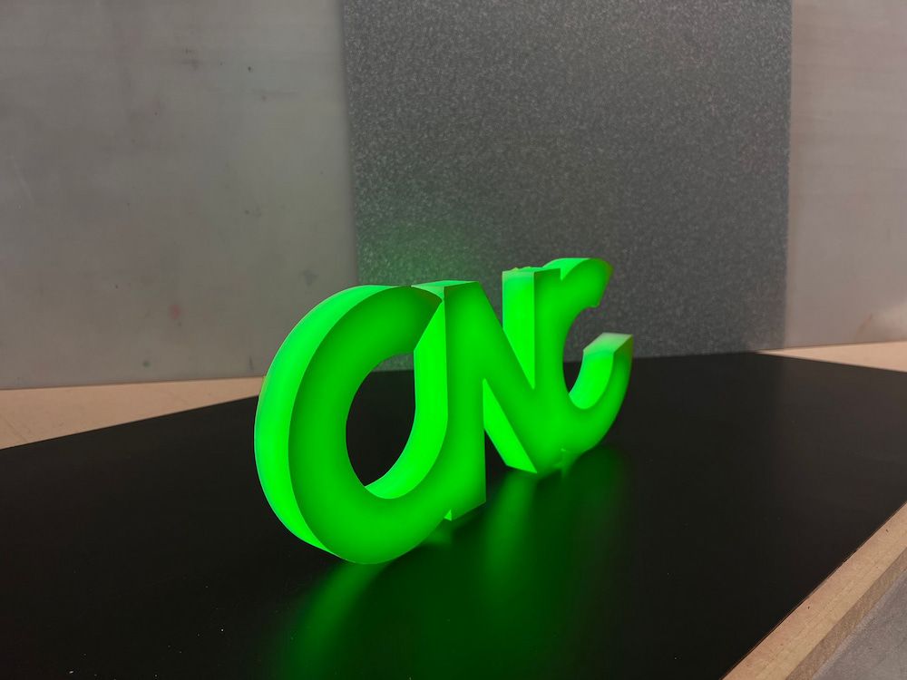 A Green CNC Sign is Sitting on a Table — Metric CNC In Morisset, NSW
