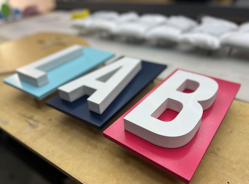 The Letters Lab Are Sitting on a Wooden Table — Metric CNC In Morisset, NSW