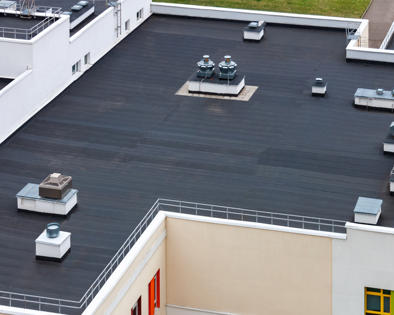 an aerial view of a building with a black roof