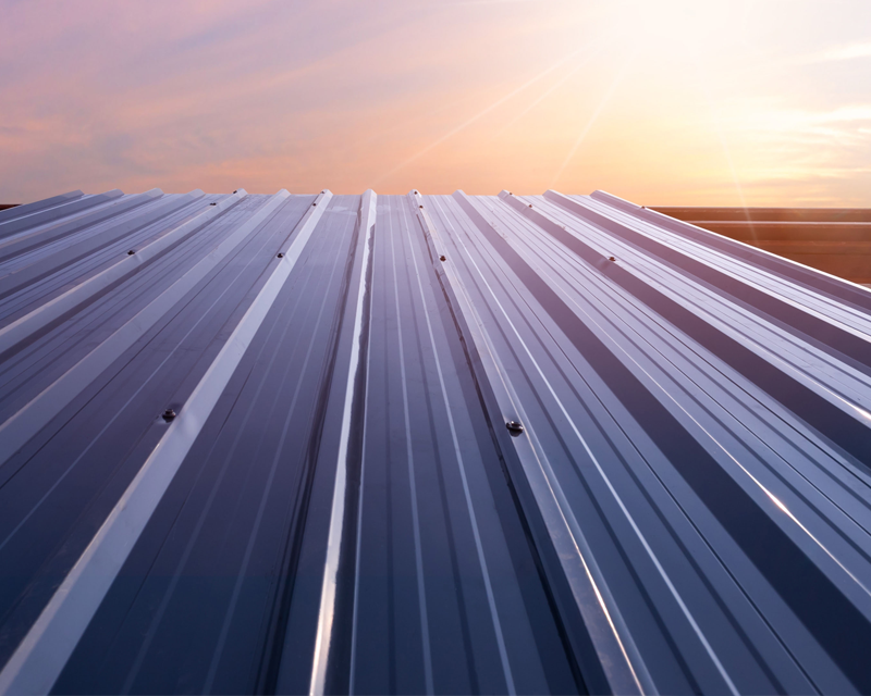 a metal roof with a sunset in the background