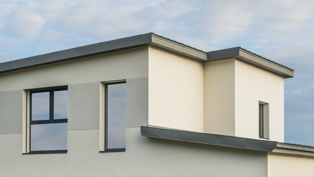 a white house with black windows and a roof .