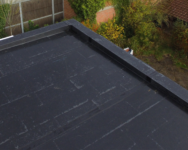 an aerial view of a black roof with a garden in the background .