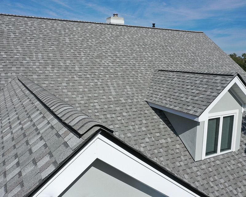 an aerial view of a house with a gray roof and a window .