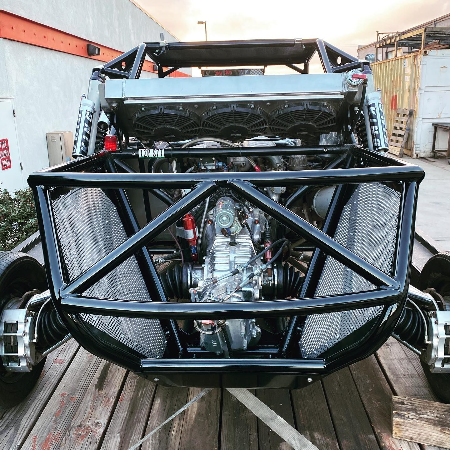 Custom off-road buggy with a black tubular front bumper in a workshop garage