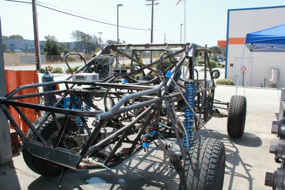 Open-frame off-road dune buggy chassis with large tires parked outdoors