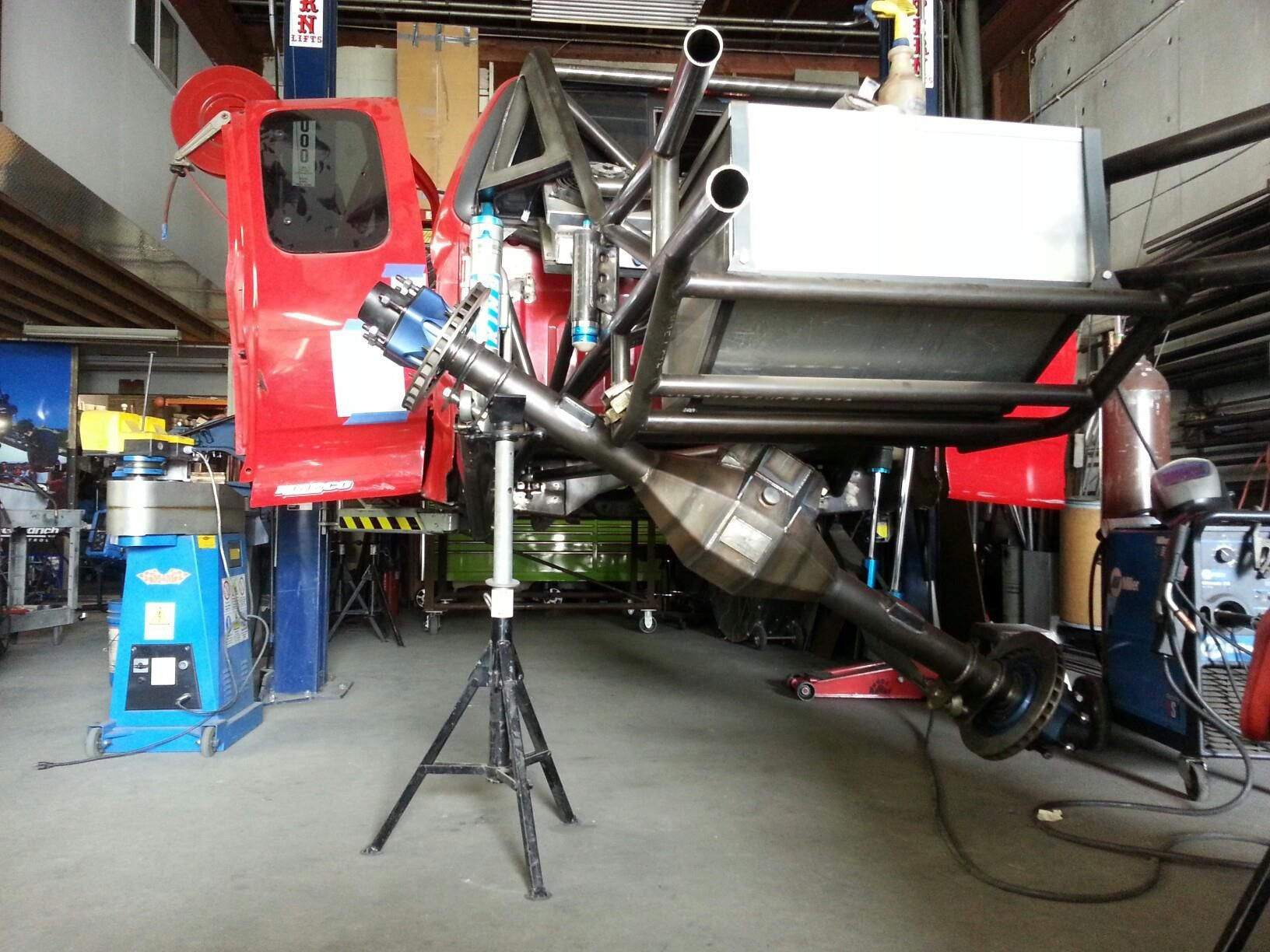 Red aircraft in a hangar with a large mounted metal platform and equipment around it