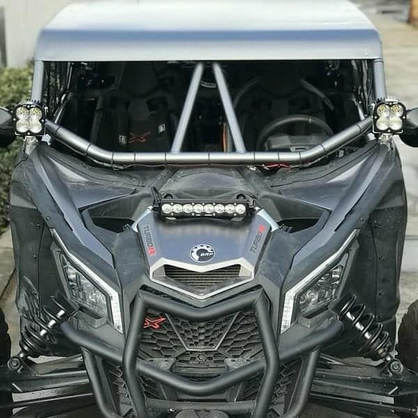 Front view of a black off-road buggy with a white roof, roll cage, and large tires
