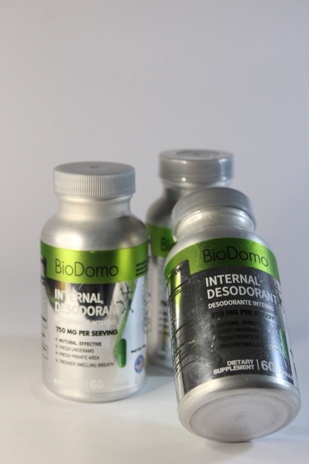 Tres botellas plateadas del suplemento dietario desodorante interno BioDomo.