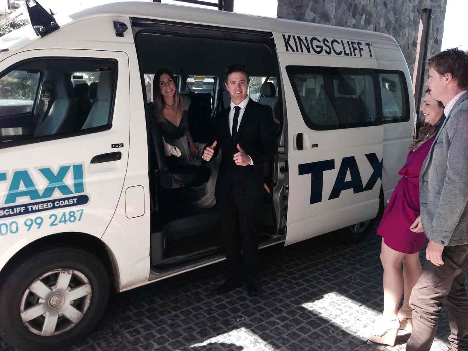 A Group Of People Standing In Front Of A White Van — Kingscliff Tweed Coast Taxis Pty Ltd In Kingscliff, NSW