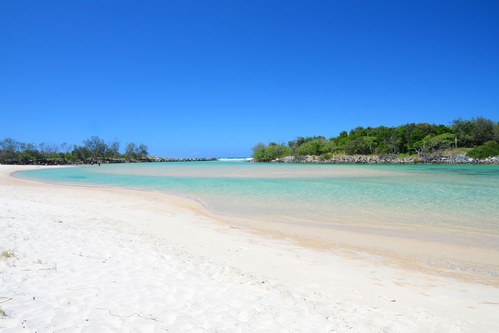 A White Sandy Beach With A Body Of Water In The Background — Kingscliff Tweed Coast Taxis Pty Ltd In Pottsville, NSW