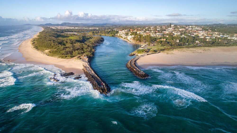 An Aerial View Of A River Flowing Into The Ocean Next To A Beach — Kingscliff Tweed Coast Taxis Pty Ltd In Chinderah, NSW